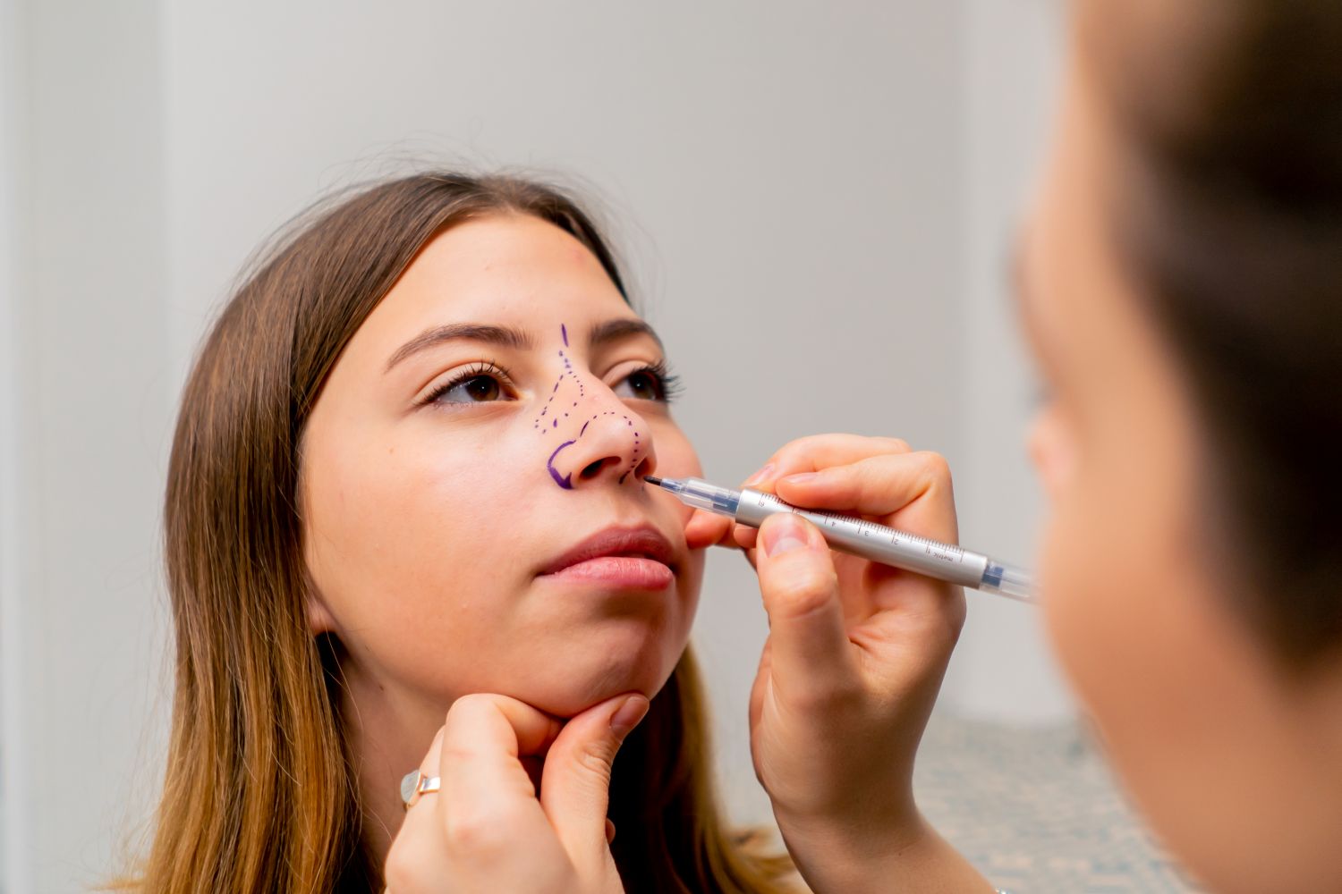 close up of plastic surgeon marking nose