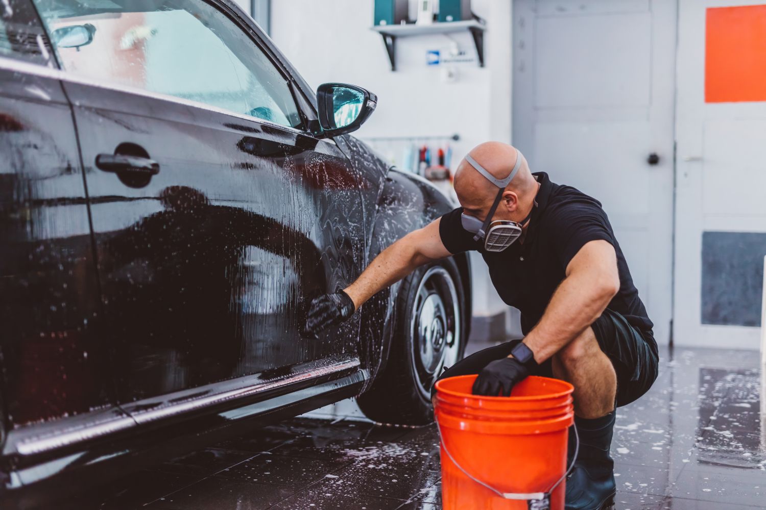 service man cleaning black car